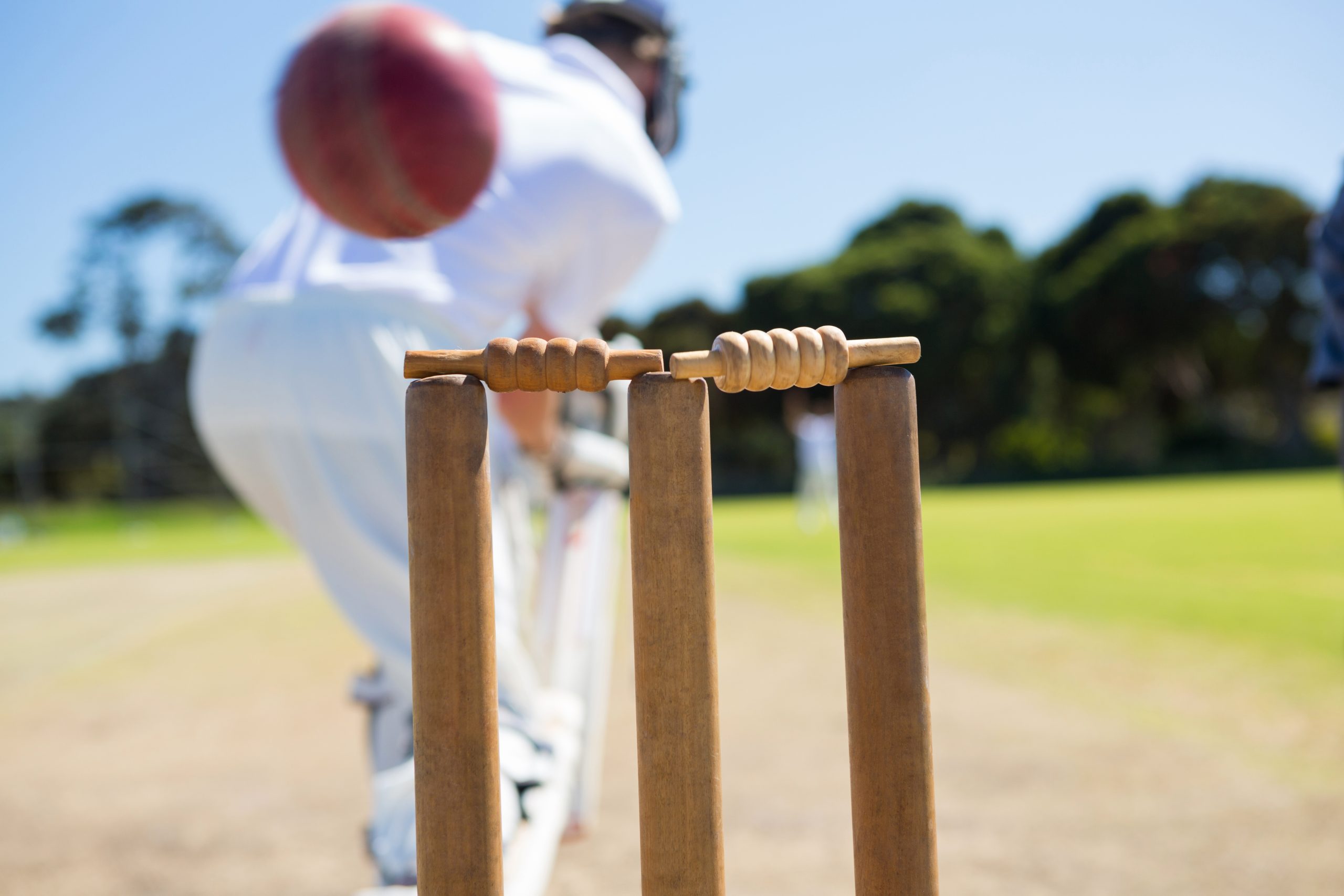 close up of ball by stump against batsman on field