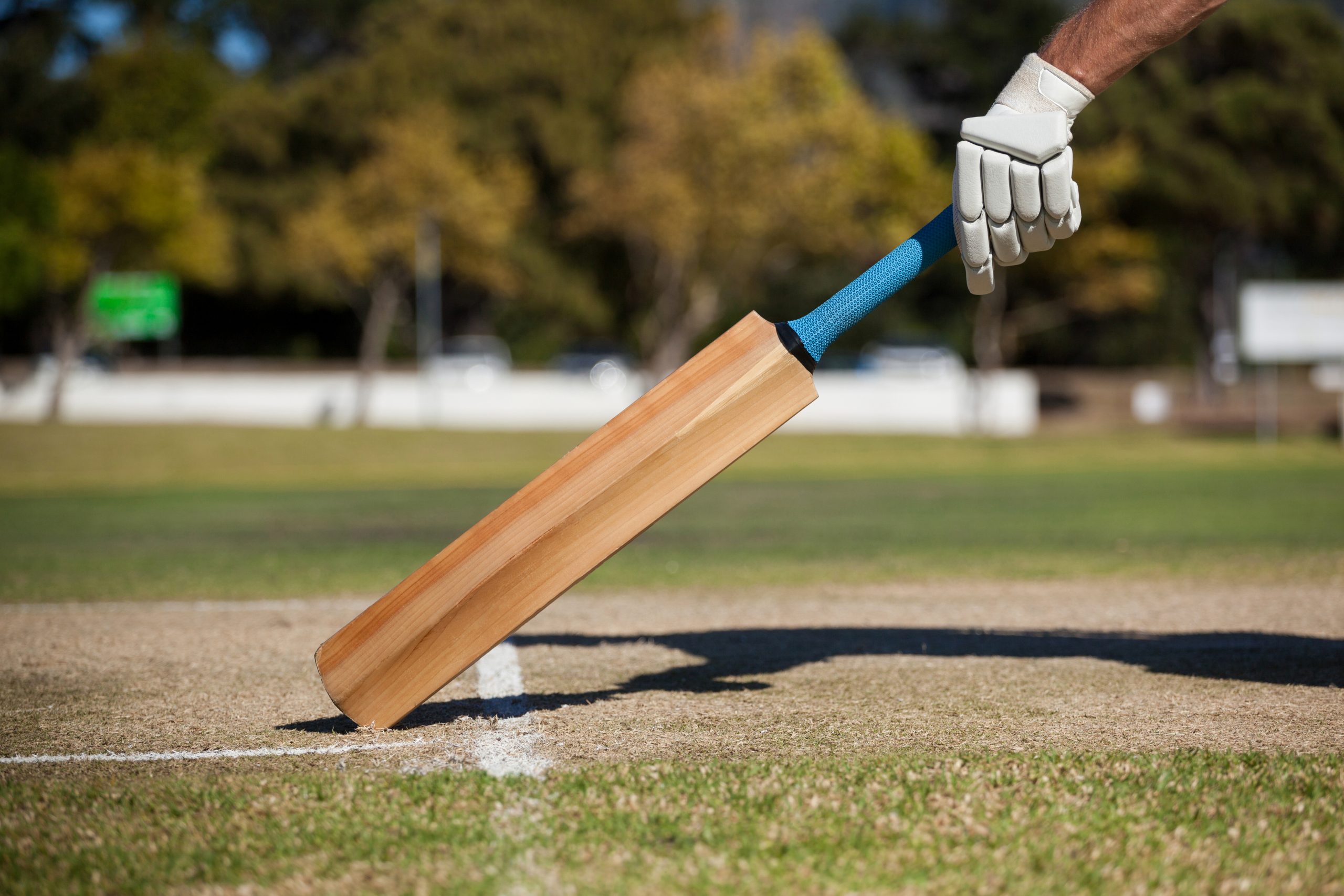 cropped image of player scoring run on cricket field